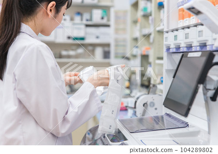 A pharmacist who uses an automatic packaging machine at a pharmacy or drug store to prepare powdered medicine, dispensing, and prescriptions A pharmacist who uses an automatic packaging machine at a pharmacy or drug store to prepare powdered medicine, dispensing, and prescriptions 104289802