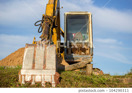 A large construction excavator of yellow color on the construction site A large construction excavator of yellow color on the construction site 104290311