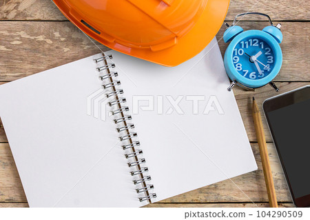 Top view with blank empty notebooks or notepad, alarm clock and pencil on wood table. 104290509