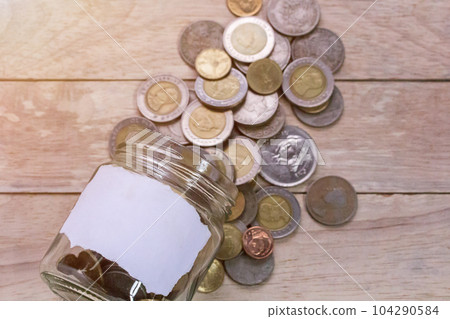 Close up saving money into a glass jar for cash in future investment. Close up saving money into a glass jar for cash in future investment. 104290584