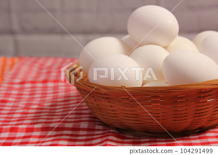 Basket of Farm Fresh Eggs on Red and White Checkered Fabric 104291499