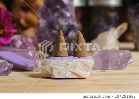 Amethyst Crystals With Flowers and Incense Cones on Meditation Table 104291682