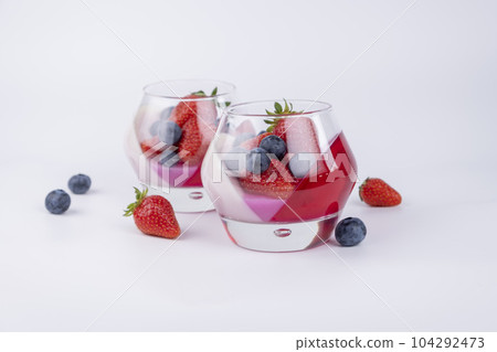 Fruit jelly dessert or panna cotta with fresh strawberries and blueberries, top view, banner, copy space, menu, template for texts on white background. 104292473