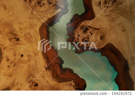 The texture of a wooden table covered with epoxy resin. Top view of a tree as a background with space to copy. High quality photo 104292972