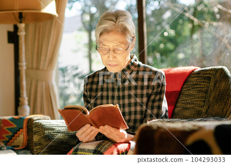 Elderly woman reading on the sofa Elderly woman reading on the sofa 104293033