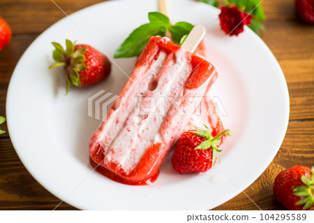 homemade strawberry ice cream on a stick in a plate with strawberries 104295589