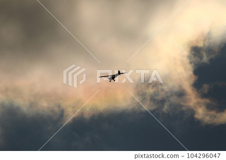 Small plane flying in the sky against dark clouds Small plane flying in the sky against dark clouds 104296047
