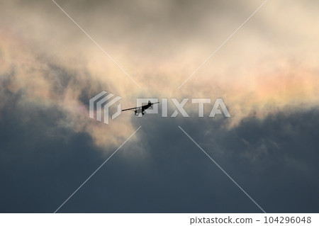 Small plane flying in the sky against dark clouds Small plane flying in the sky against dark clouds 104296048