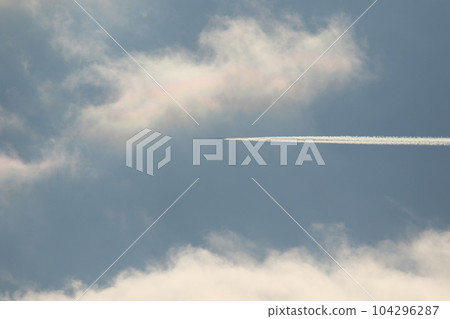 A plane and vapor trails in the sky 104296287