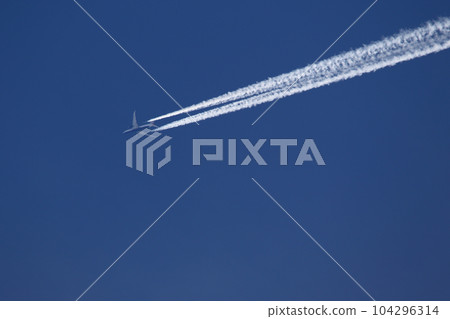 A plane and vapor trails in the sky 104296314
