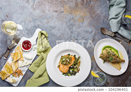 Big dinner table overhead view with steak and fish 104296401