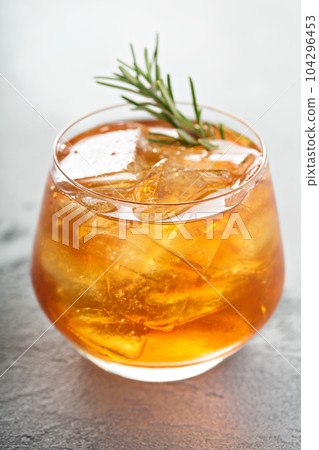 Old fashioned cocktail with ice and rosemary 104296453