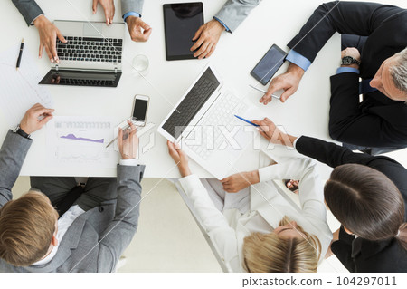 Business people brainstorming at office desk Business people brainstorming at office desk 104297011