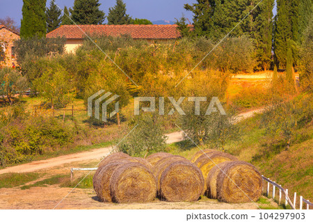 Tuscany landscape with farm and hay bales, Italy 104297903