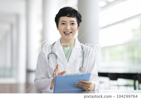 中位女醫生一邊看著鏡頭一邊說話 104299764
