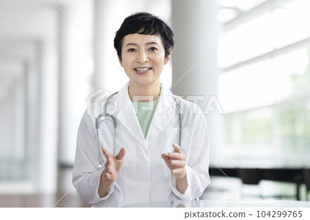 中位女醫生一邊看著鏡頭一邊說話 中位女醫生一邊看著鏡頭一邊說話 104299765