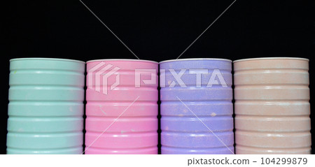 multi-colored jars or containers for small items on a black background 104299879