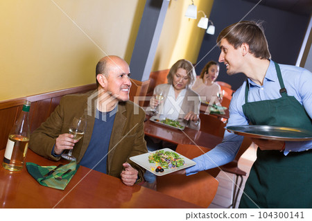 Waiter and mature man in restaurant . 104300141