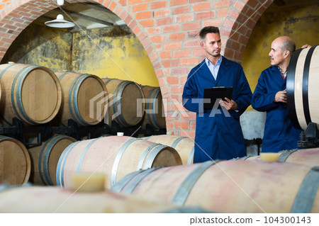 Two happy men winery employees writing note 104300143