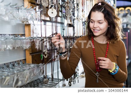 Girl seller offering fashionable bracelets and pendants 104300144