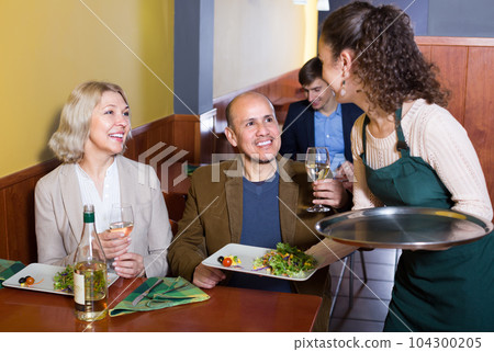 Waitress serving senior customers . Waitress serving senior customers . 104300205