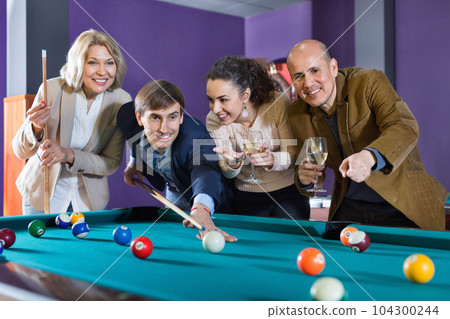 Group of pretty positive friends playing billiards 104300244