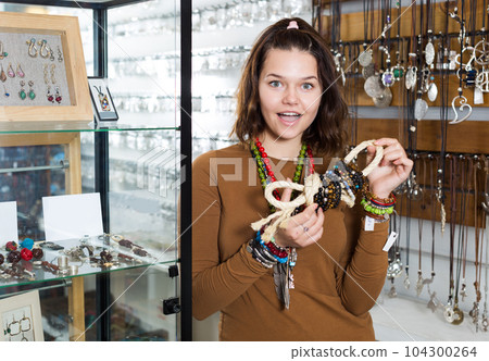 Girl seller offering fashionable bracelets and pendants Girl seller offering fashionable bracelets and pendants 104300264