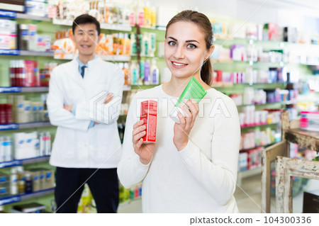 Portrait of woman client who is satisfied of recommended medicines in pharmacy. 104300336