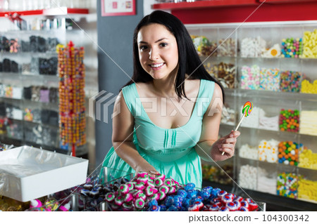 Sexy young woman with lollipop at sweets shop Sexy young woman with lollipop at sweets shop 104300342