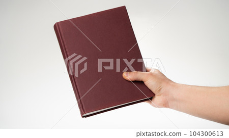 A man's right hand holds a book or notepad for writing A man's right hand holds a book or notepad for writing 104300613