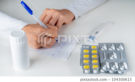 The doctor writes a medical prescription for the disease against the background of drugs, tablets The doctor writes a medical prescription for the disease against the background of drugs, tablets 104300615