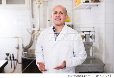 Middle aged worker standing near the table Middle aged worker standing near the table 104300731