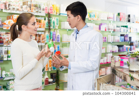 Korean man pharmacist is recommending medicine for young woman client in apothecary. Korean man pharmacist is recommending medicine for young woman client in apothecary. 104300841