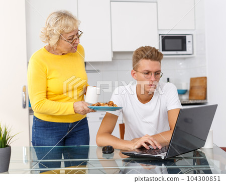 Woman taking care of adult son at kitchen Woman taking care of adult son at kitchen 104300851