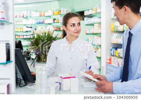 Pharmacist helping client choose medicine 104300950
