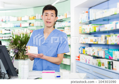 japanese specialist standing near table with cashbox in pharmacy japanese specialist standing near table with cashbox in pharmacy 104301090