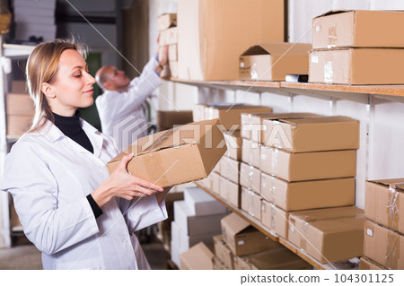 Woman worker standing with boxes at factory 104301125