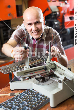 Workman making mailbox plate in workshop. Workman making mailbox plate in workshop. 104301168