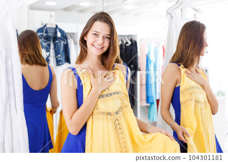 Woman trying dress in fitting room Woman trying dress in fitting room 104301181