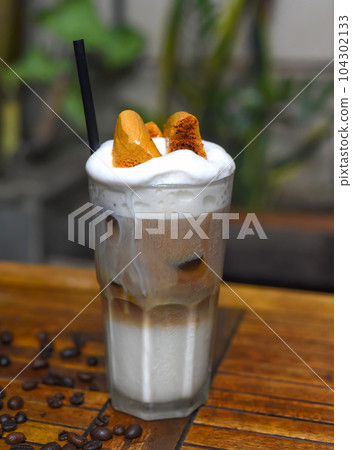 Honeycomb latte with coffee beans on wooden table Honeycomb latte with coffee beans on wooden table 104302133