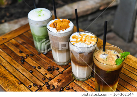 Coffee beverages with coffee beans on wooden table in a coffee shop Coffee beverages with coffee beans on wooden table in a coffee shop 104302144