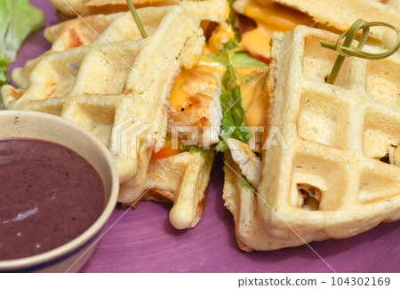 Belgium waffles with pan fried chicken on purple plate Belgium waffles with pan fried chicken on purple plate 104302169