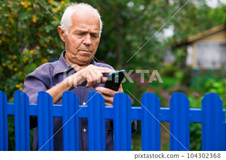 Senior man using smartphone outdoors Senior man using smartphone outdoors 104302368