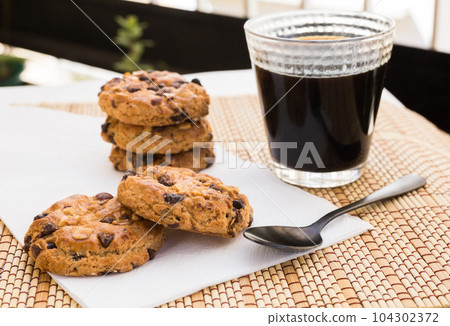 cookies with chocolate and hazelnuts and coffee are on table cookies with chocolate and hazelnuts and coffee are on table 104302372