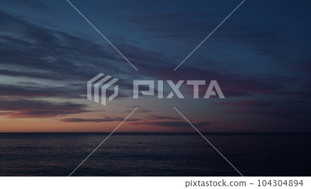 Beautiful sunset with purple clouds and flying birds over the sea Beautiful sunset with purple clouds and flying birds over the sea 104304894