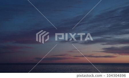 Beautiful sunset with purple clouds and flying birds over the sea Beautiful sunset with purple clouds and flying birds over the sea 104304896