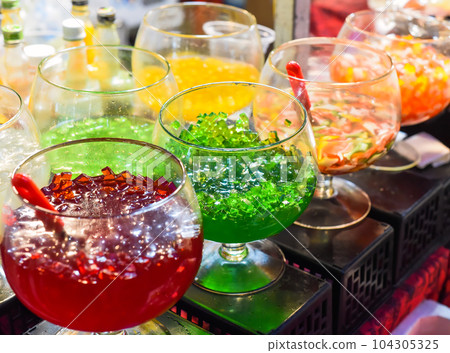 Different fruit jelly in glass bowls for tea and ice cream in vietnamese night market 104305325