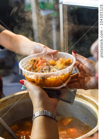 Vietnamese woman serving noodles soup with meat in vietnamese night market in food festivalm person buying 104305328