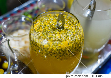 Glass with passion fruit juice with seeds for preparation of drinks in the vietnamese food festival 104305339