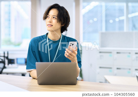 Young male engineer operating a smartphone 104305560